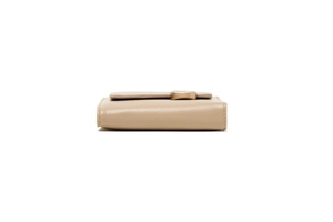 Detail view of the beige leather compact wallet showing side stitching and gold metal buckle
