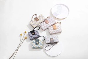 Flat lay of multiple printed long wallets with wrist straps and metal Pd buckle details