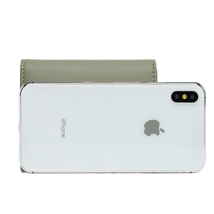 Size comparison of a sage green trifold wallet with a smartphone on white background