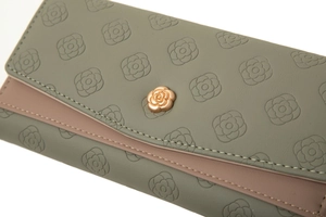 Detail der Kamelien-Prägung und des roségoldenen Blumenverschlusses am Portemonnaie