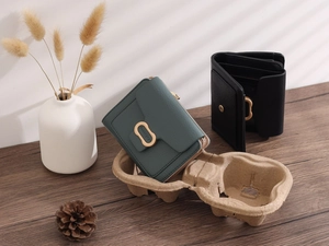 Close-up of minimalist women's short wallets in green and black with gold metal clasps