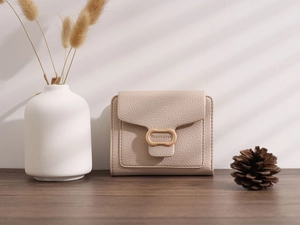 Detail of beige lychee textured PU leather wallet featuring a unique metal buckle ring