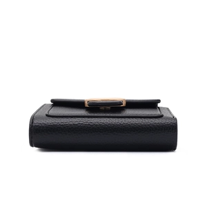 Detail view of black lychee grain faux leather purse with elegant golden clasp