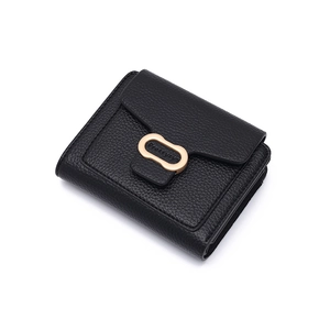 Detail view of black lychee grain leather wallet with golden oval buckle and logo