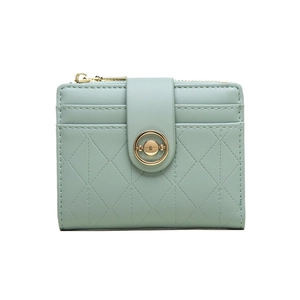Detail of mint green quilted wallet with gold circular twist lock and multi-card slots
