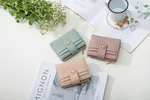 Close-up of quilted leather wallets with gold buckles in pastel green and pink