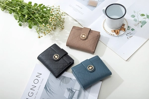 Short quilted leather wallets in black, taupe, and teal with round metal buckles and card slots