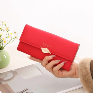 Vue détaillée d'un portefeuille long rouge pour femme avec boucle feuille dorée élégante