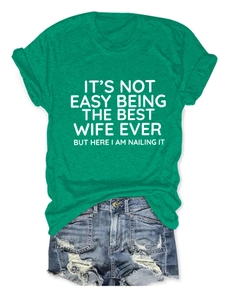 Dettaglio della t-shirt verde in cotone con scritta e pantaloncini in denim strappati