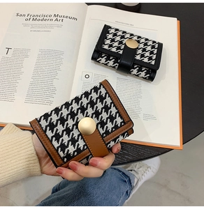 Detail showing the classic houndstooth patterns and gold buckle on short folding wallets
