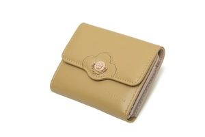 Detail of yellow trifold wallet showing floral metal buckle and wavy edge embroidery