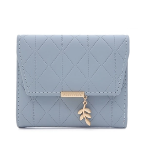 Détail du portefeuille à trois volets bleu clair avec motif matelassé et bijou feuille