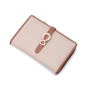 Detail of beige lychee grain wallet with brown trim and matte gold bow clasp