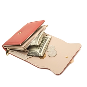 Detailed interior of a coral red and beige bifold wallet showing card slots and coin pocket