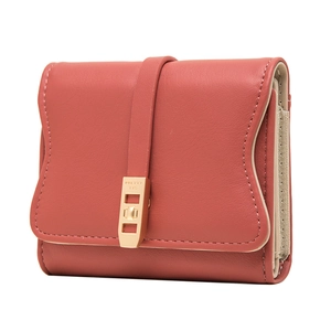 Detail of brick red leather wallet with lychee texture and engraved gold buckle clasp