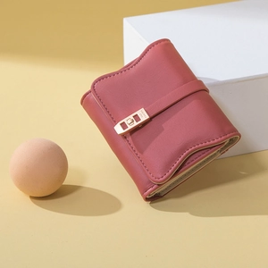 Detailed close-up of a burgundy PU leather wallet with a gold snap clasp on a minimalist base