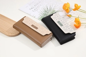 Detail of long matte leather wallets with floral embossing and metal buckle decoration