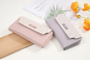 Detail of pink and purple floral flap long wallets with accordion card slots and metal buckles