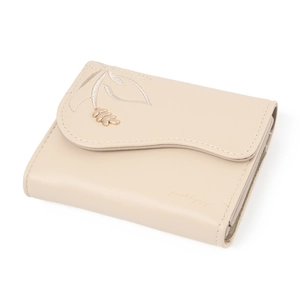 Detail of beige faux leather wallet featuring leaf embroidery and golden charm pendant