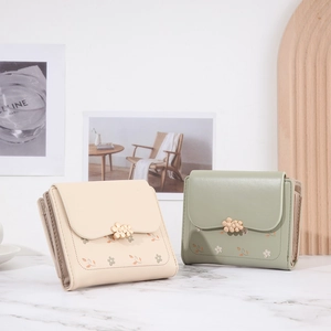 Close-up of short PU leather wallets featuring floral prints and 3D flower metal clasps
