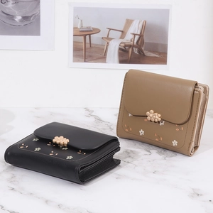 Detailed view of women short wallets with floral prints and flower buckle closure