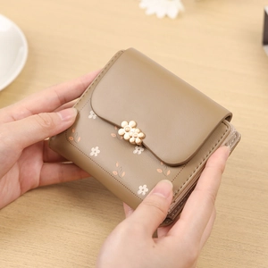 Detail of khaki PU leather short wallet with white floral print and gold metal clasp