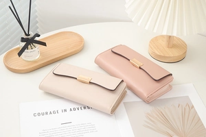 Vue détaillée de portefeuilles longs en similicuir beige et rose avec boucles dorées