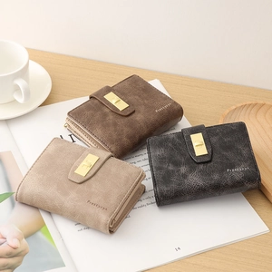 Detailed view of vintage PU leather wallets with elegant metal twist locks on a wooden desk