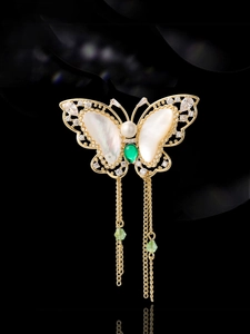 Macro view of butterfly brooch with shell wings, zirconia accents and dangling tassels