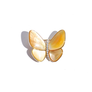 Detalle de broche de mariposa con baño de oro y nácar amarillo con cristales brillantes