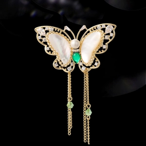 Elegant gold butterfly brooch with shell wings, pearls, and green zircon tassels