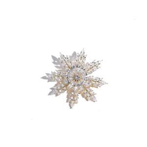 Macro d'une broche flocon de neige 3D avec zircons étincelants sur base métal argenté