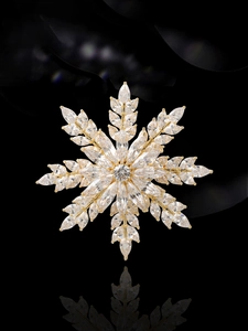 Vue macro d'une broche flocon dorée rotative ornée de zircons brillants marquise