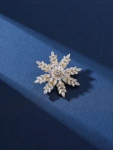 Vue détaillée de la broche flocon dorée ornée de zircons brillants de haute qualité