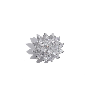 Detailed macro view of a luxury silver lotus brooch with sparkling zircon petals