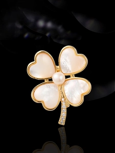 Détail de la broche fleur en nacre avec perle centrale et tige sertie de zircons