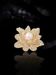 Macro shot of gold lotus brooch with cubic zirconia petals and a natural pearl center