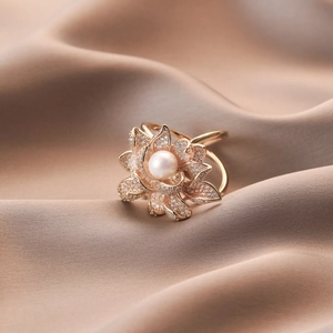 Gold lotus scarf clip with zircon pavé petals and a lustrous natural pearl center