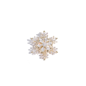 Vue détaillée d'une broche flocon de neige dorée avec des cristaux et zircons incrustés