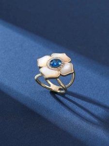 Detail of flower scarf ring with mother of pearl petals and a blue center stone