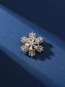 Détail macro d'une broche flocon dorée sertie de cristaux étincelants et gemmes carrées