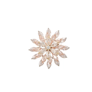 Macro detail of rose gold sunflower brooch with radiant marquise-cut pink cubic zirconia