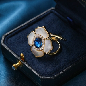 Elegant flower ring with dark blue gemstone, white shell petals and gold plating