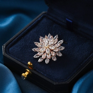 Elegant rose gold rotating pink zircon flower brooch pinned to a deep blue velvet gift box