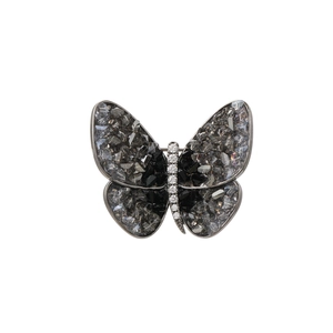 Macro detail of butterfly brooch with dark grey crystals and silver metal framing