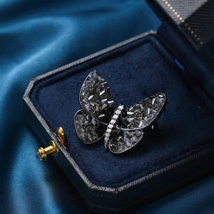 Elegant butterfly brooch featuring smoky crystals and white zircons on blue velvet