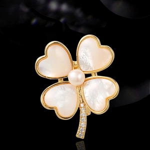 Broche trèfle élégante avec pétales en nacre blanche et tige dorée sertie de cristaux
