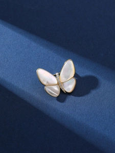 Macro detail of elegant butterfly brooch featuring natural shell wings and cubic zirconia