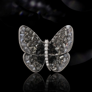 Elegant butterfly brooch with smoky grey crystals and silver base on black background