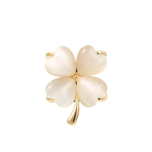 Détail d'une broche trèfle à quatre feuilles avec œil de chat blanc laiteux et métal doré
